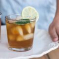 Frau trägt ein Tablett mit Sauerkrauftsaft mit Eiswürfeln