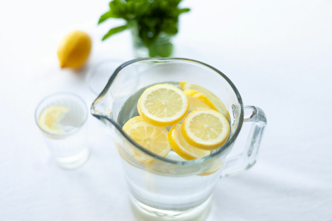 Glaskaraffe mit Wasser und frischen Zitronenscheiben