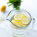 Glaskaraffe mit Wasser und frischen Zitronenscheiben