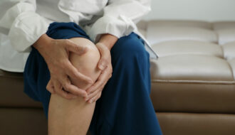 Frau hält sich ihr schmerzendes Knie