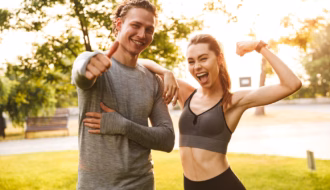 Aufgeregtes Fitness-Sport liebendes befreundetes Paar zeigt Bizeps vor der Kamera.