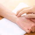 Ayurveda Arzt misst den Puls bei einer Patientin am Handgelenk
