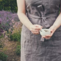 Eine Frau hält in ihren Händen einen Mörser mit Frauenkraut. Die Kräuterfrau sammelt medizinische Pflanzen im Garten.